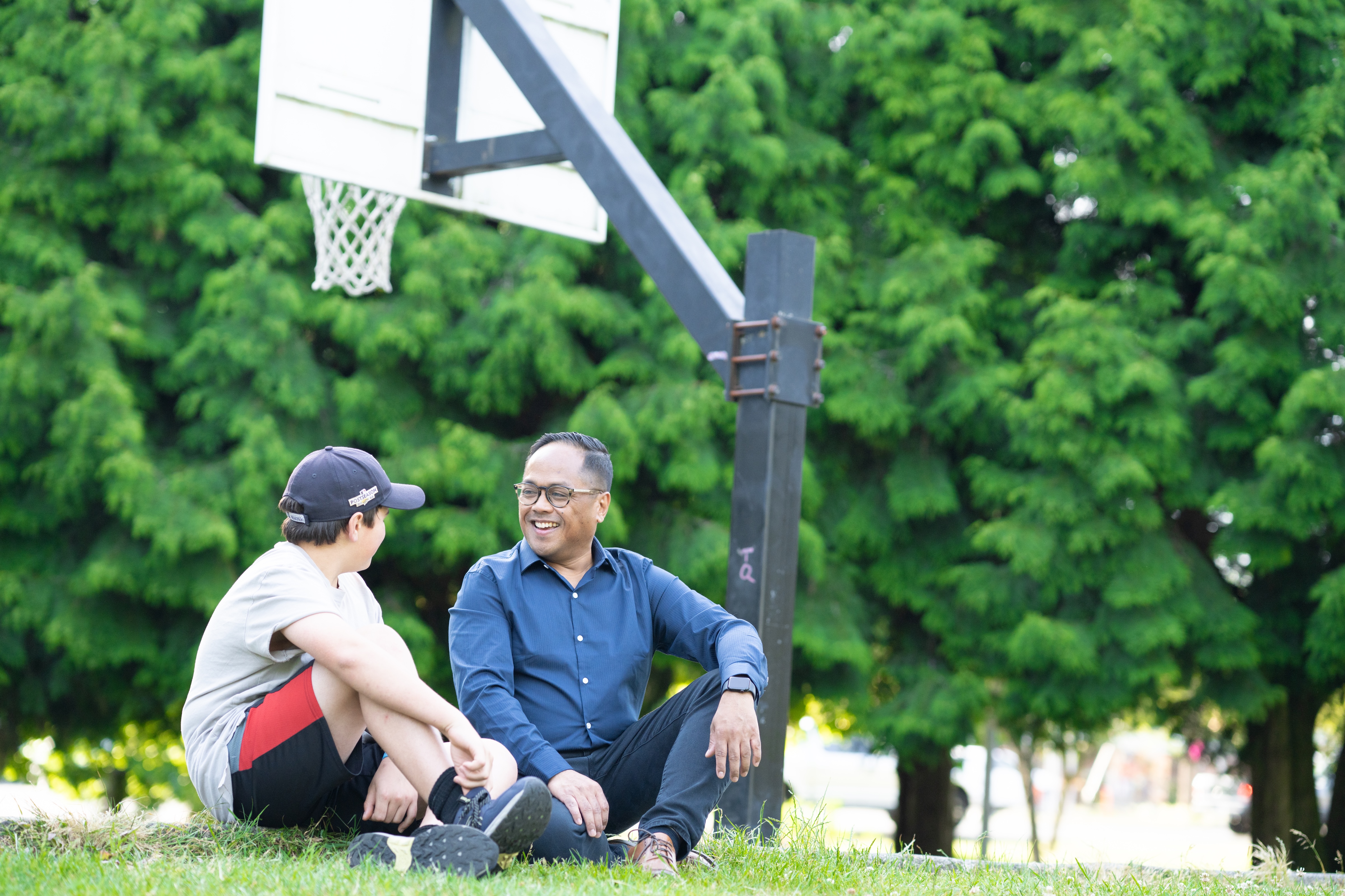 Edwin sitting and chatting with a neighbor at a basketball court